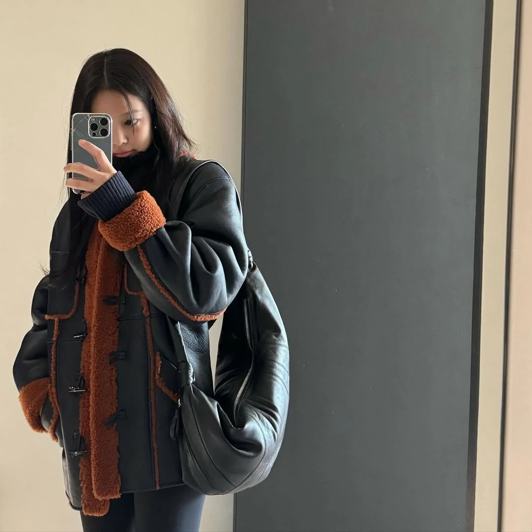 提到Lemaire，可頌包幾乎是許多時裝迷心中的第一個答案。包身以可頌麵包的弧形為靈感，透過拼接面板與打結細節勾勒出流暢曲線，整體輪廓柔和卻極具辨識度。Jennie私下穿也曾背上可頌包入鏡，低調卻相當搶眼。除了造型討喜，實用度也很到位，小款可放手機與錢包，中大型容量更充裕，雨傘也放得下，肩背、斜背或手提都可以，也難怪成為許多人入門Lemaire的第一款包。