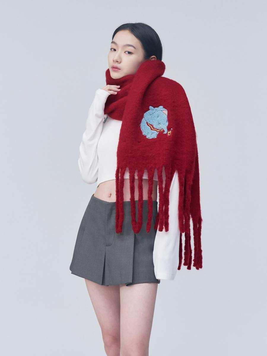 由台灣 KOL「大饅大力」創立的電商女裝品牌 mouggan，今年冬季與 Disney 小飛象聯名，推出超可愛的連帽圍巾。帽子可拆卸的設計，讓單品在實用性上更具彈性，既能作為完整連帽圍巾，也能回歸純圍巾使用。立體毛巾繡圖案成為視覺焦點，細節處理細膩，不流於平面印花。長達265公分的長度，讓流蘇自然垂墜，修飾身形比例。對於想在年節穿搭中加入一點童趣元素的人來說，這款非常推薦。