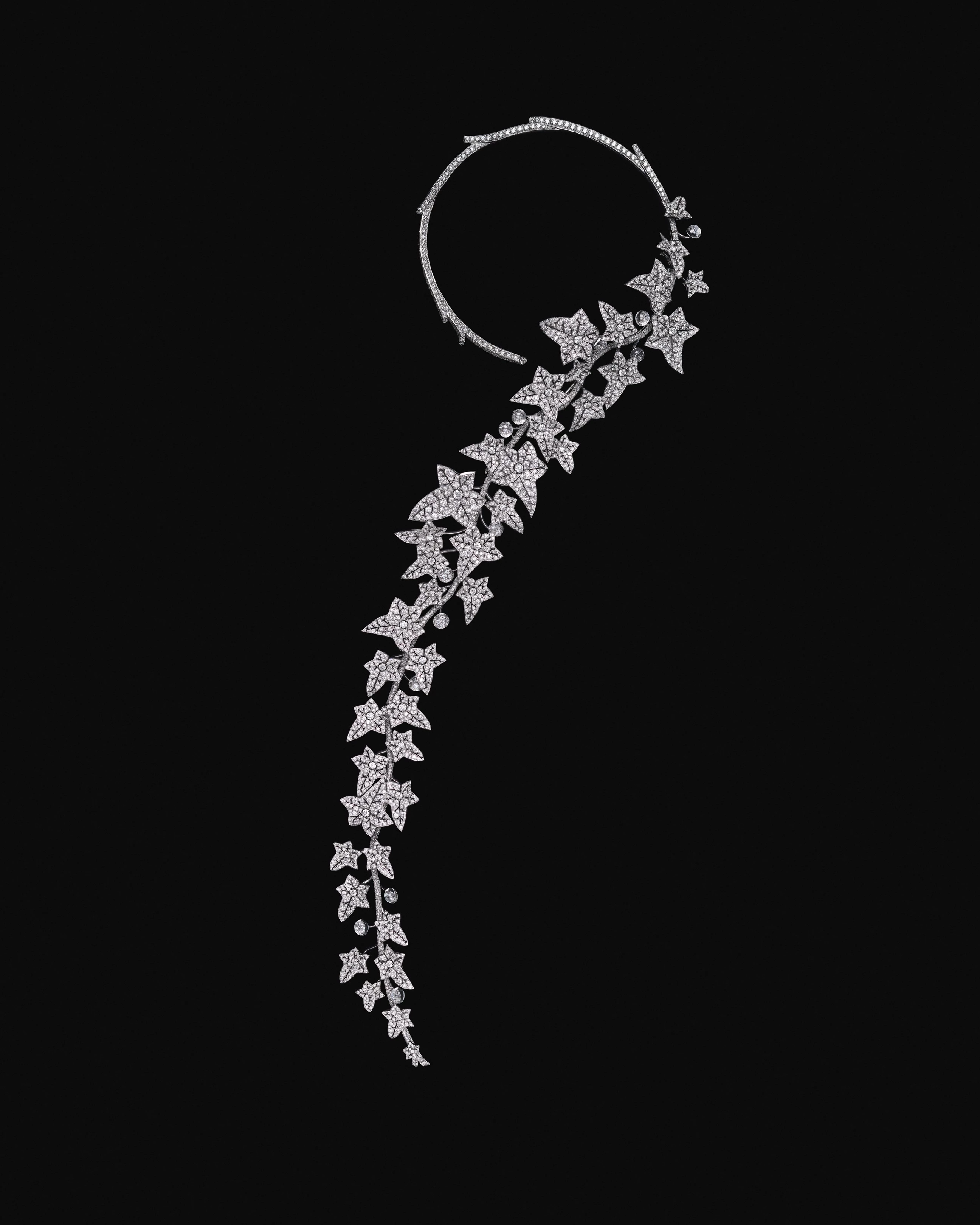 在一個習慣將自然「美化」的年代，寶詩龍先生卻偏愛未經修飾的生命狀態。當別人追捧玫瑰與百合，他鍾愛的則是不按牌理生長的常春藤。對他而言，自然之美並不在於被修剪後的完美輪廓，而在於其真實、野性且持續生長的狀態。今年的收尾作品〈The Untamed〉，正是這份觀點的具體呈現，將經典問號項鍊的輪廓延伸至近乎人體藝術的比例，鑲嵌鑽石的藤蔓沿著身體曲線自然垂落，隨動作擺盪，彷彿正在生長。整體結構可拆卸、可轉換，透過多重關節系統，回應不同佩戴方式與身體姿態。水晶雕琢的果實、逐片製作的葉片，以及輕顫結構所帶來的細微律動，使作品不再只是對自然的描寫，而是近乎模擬生命本身的節奏與呼吸。它野性卻精準，證明自由與工藝從來不是對立面，而是可以相互成就的核心價值。