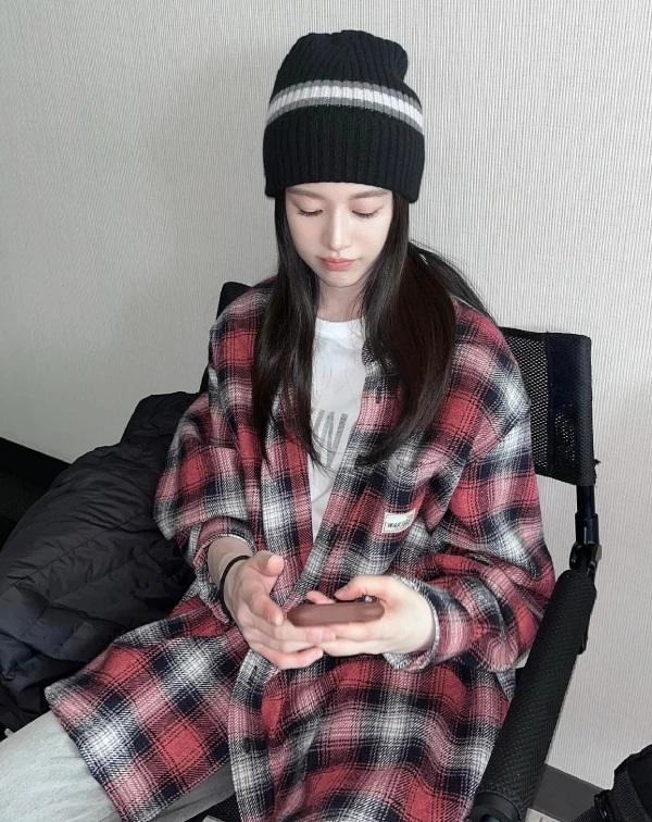 這套真的就是那種「看起來很隨便，但其實很會搭」的休閒感穿搭。紅黑格紋襯衫本身就很有存在感，直接當外套披著就很有型，內搭一件白T，乾淨又有層次，怎麼看都不會亂。再戴一頂黑色毛帽，把視覺往上拉，整體多了一點街頭感，也剛好把格紋的隨性感平衡掉。
