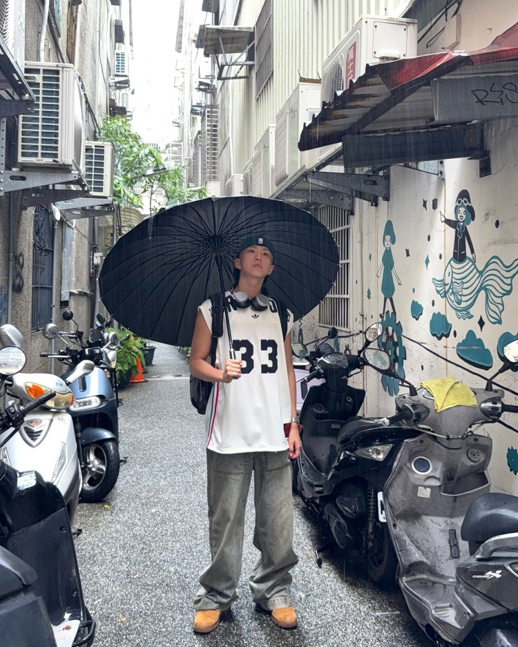 Seventeen Hoshi這套台北街拍造型，以上寬下寬的穿搭邏輯，展現運動混搭機能的時髦感，上身愛迪達的白色無袖籃球背心，以及灰色洗舊感的Entire Studios寬版牛仔褲，其中最吸睛的配件莫過於這款Tumi多口袋後背包，來自經典Alpha系列