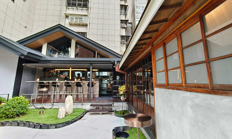 圖中右側具有歷史痕跡的居所改為用餐空間，左側則新建廚房與吧台，修復時的瓦片也作為庭院裝飾。（圖／魏妤靜攝）
