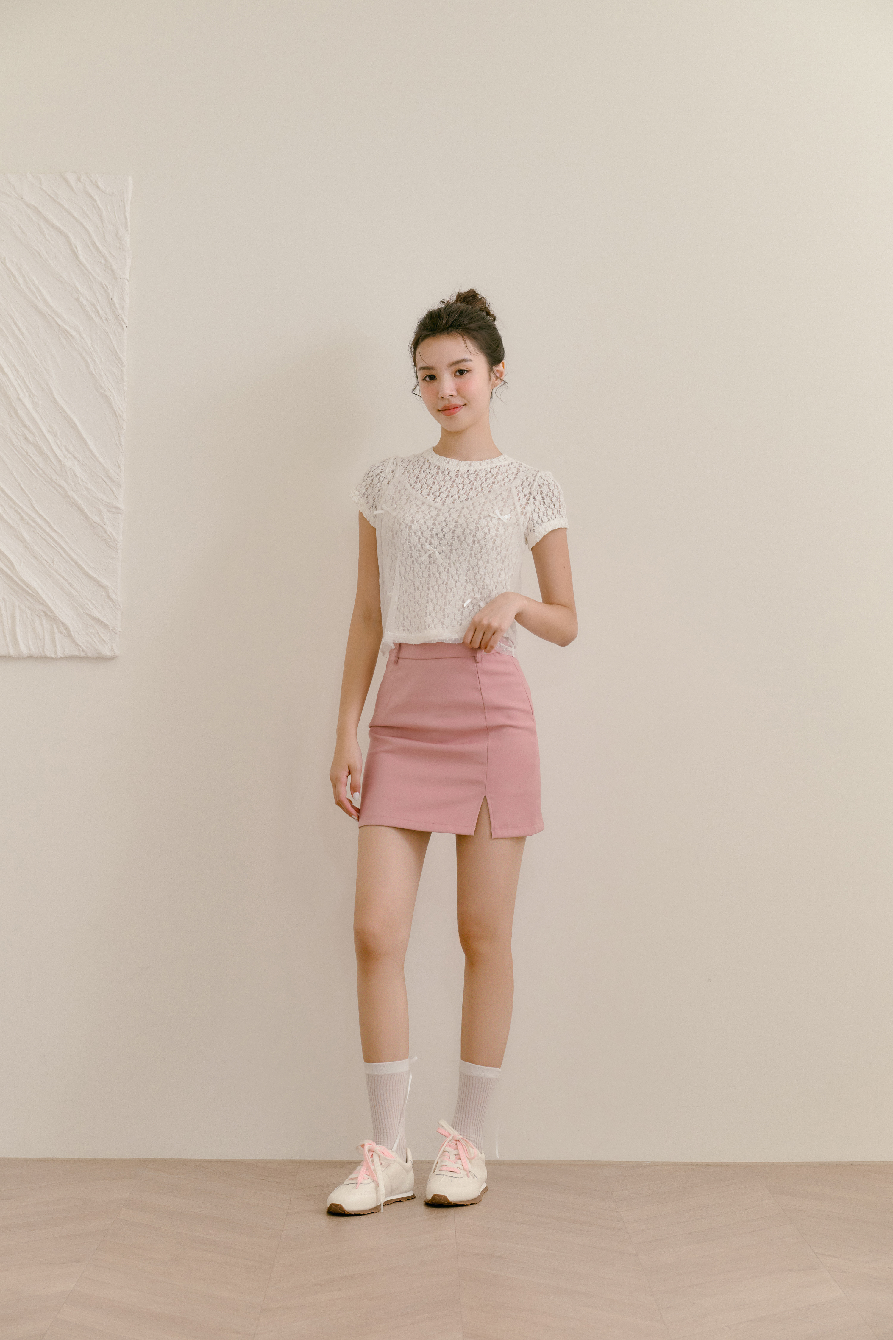 D+AF 白色運動鞋搭配粉色短裙與蕾絲上衣，展現甜美學院風穿搭