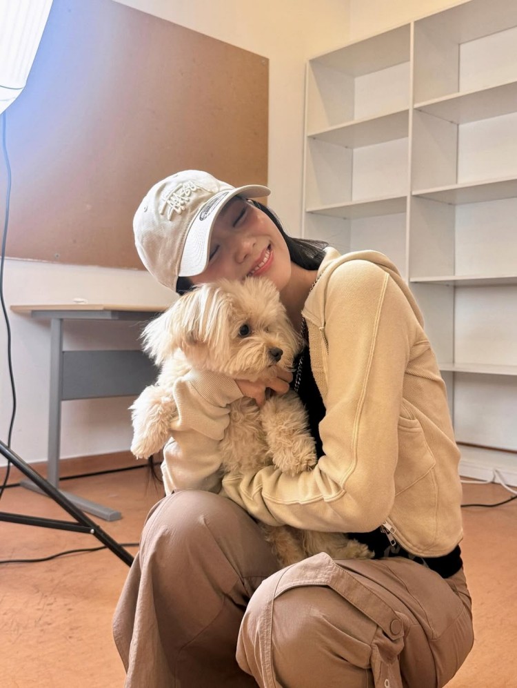 Jisoo將運動風穿出療癒可愛的一面！米色連帽外套搭配同色系工裝褲，運用柔和中性色調營造日常氛圍，內搭黑色背心讓層次更立體，帽子上的立體刺繡則增添街頭感細節。