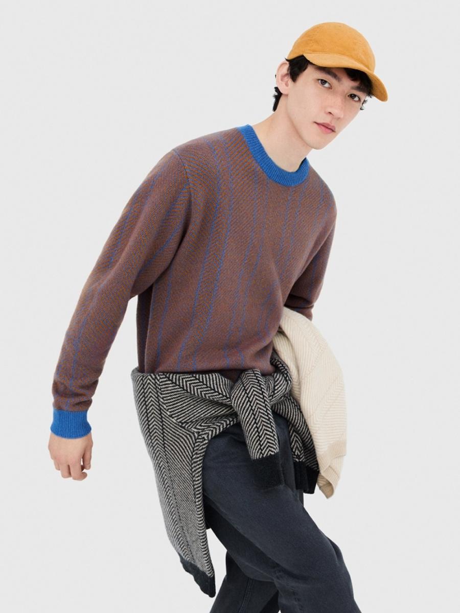 此款毛衣以 100% 羊毛編織，質地細膩且可手洗，為日常保暖選擇之一。設計上運用雙色調人字紋（Herringbone）圖案，讓整體視覺層次更豐富。版型取寬鬆中等寬版，具中性設計風格，適合男女共穿。