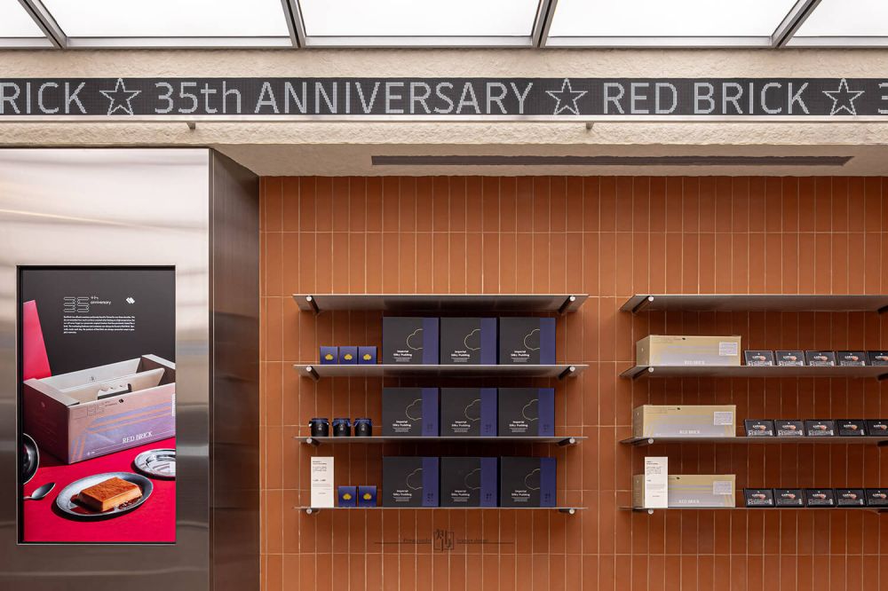 跳脫既定的甜點店形式，Red Brick 找來「知冉設計」操刀空間設計，透過大面積紅磚語彙作為主視覺調性，運用窯燒立磚鋪陳牆面，轉譯台南獨有的磚牆歷史溫度。在充滿溫暖意象之餘，也大量揉入不鏽鋼材質，並活用於櫃體、牆面與細節裝飾中，營造冷冽俐落的未來感。這個充滿現代工業風格的空間，在溫暖與冷酷之間，取得了適切的視覺平衡美學。